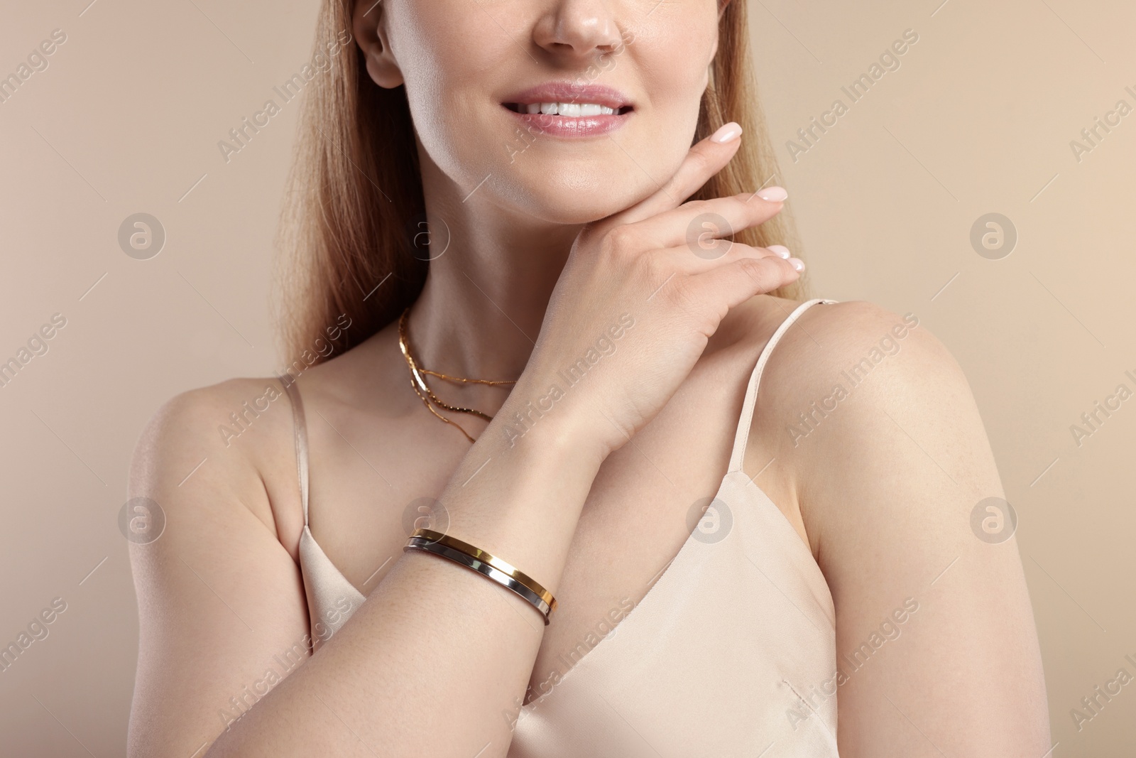 Photo of Woman with elegant jewelry on beige background, closeup