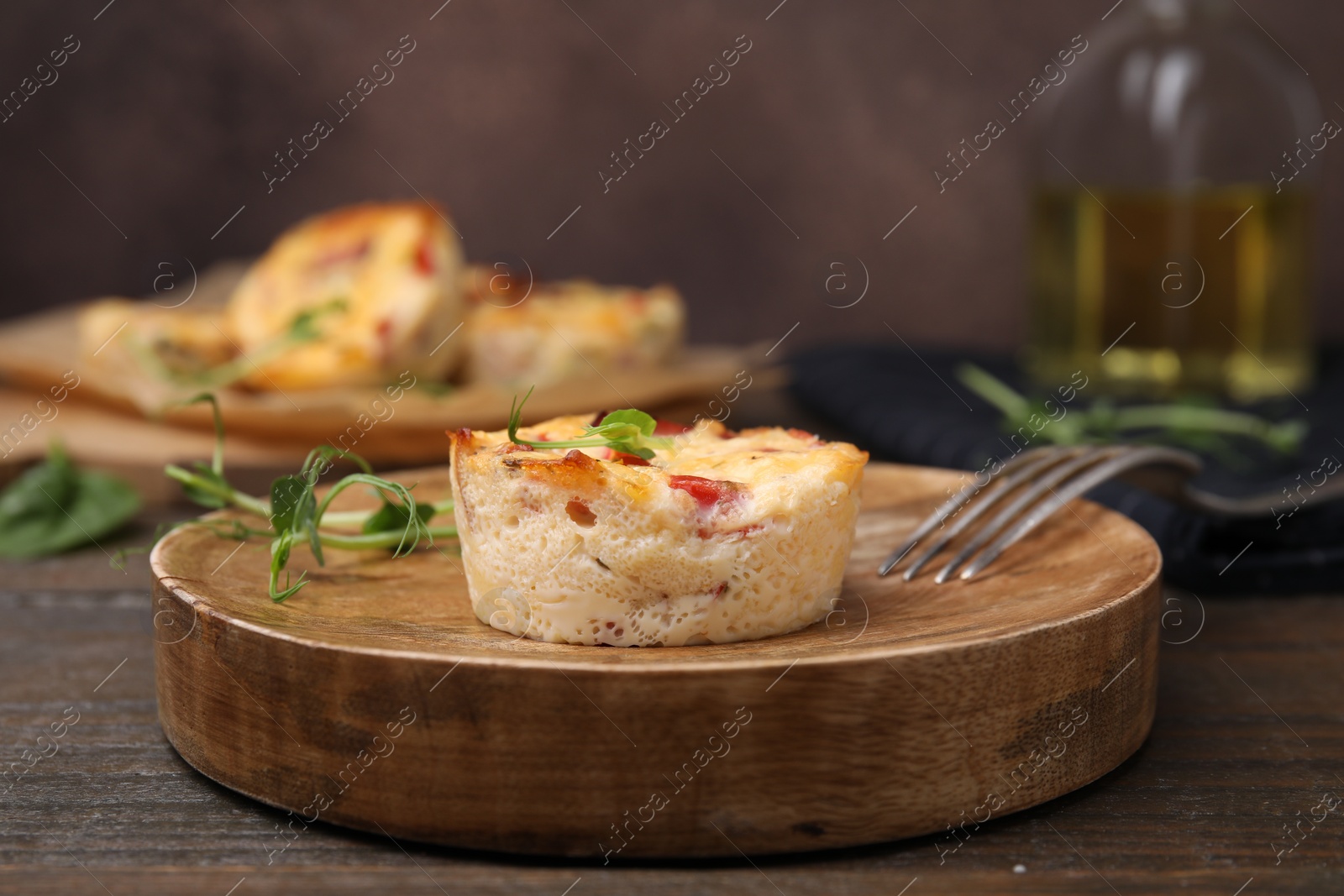 Photo of Delicious egg muffin with cheese and bacon on wooden table, closeup. Space for text