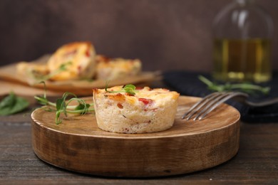 Delicious egg muffin with cheese and bacon on wooden table, closeup. Space for text