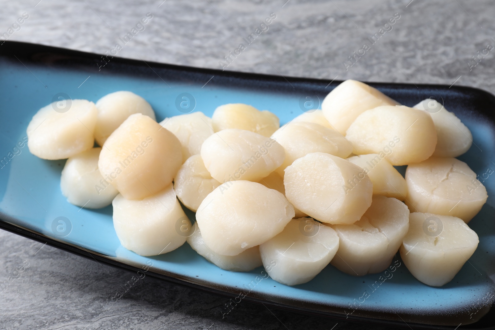 Photo of Fresh raw scallops on grey table, closeup