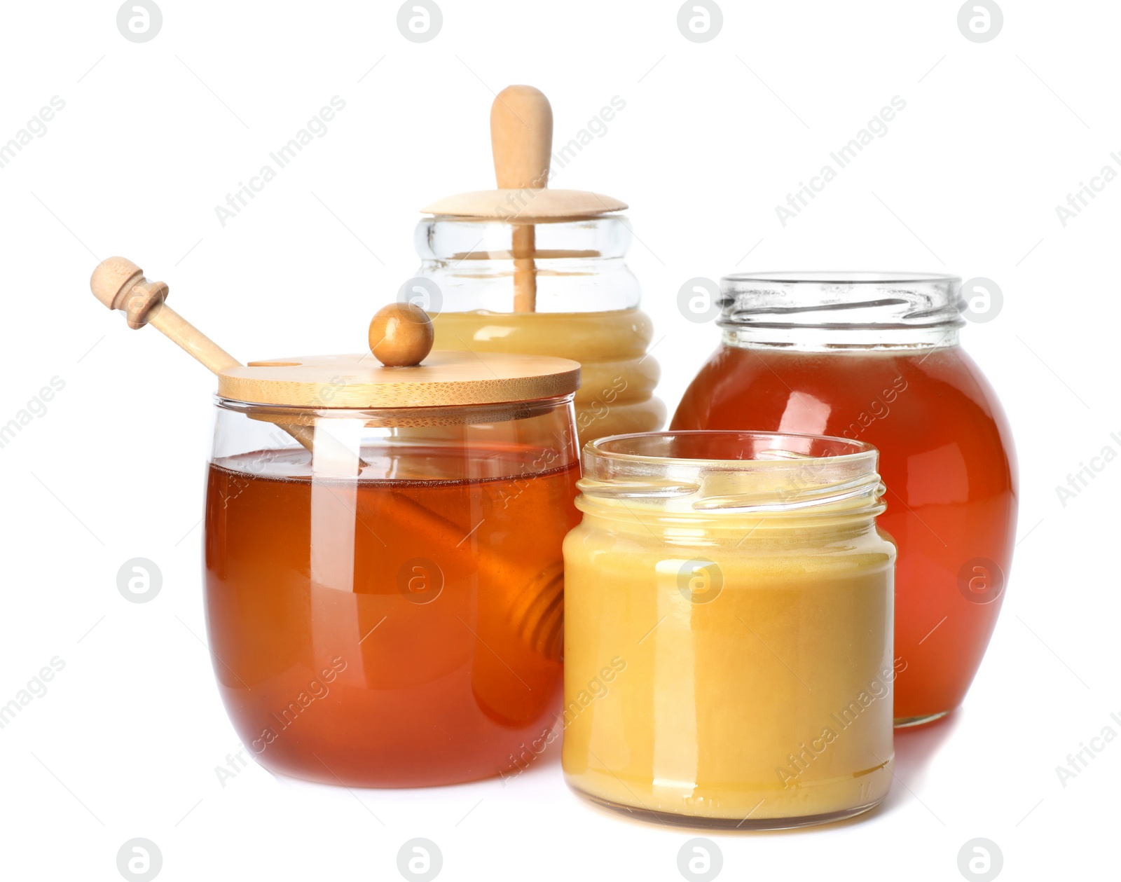 Photo of Glass jars with different types of sweet honey on white background