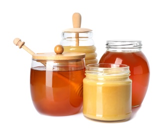 Glass jars with different types of sweet honey on white background