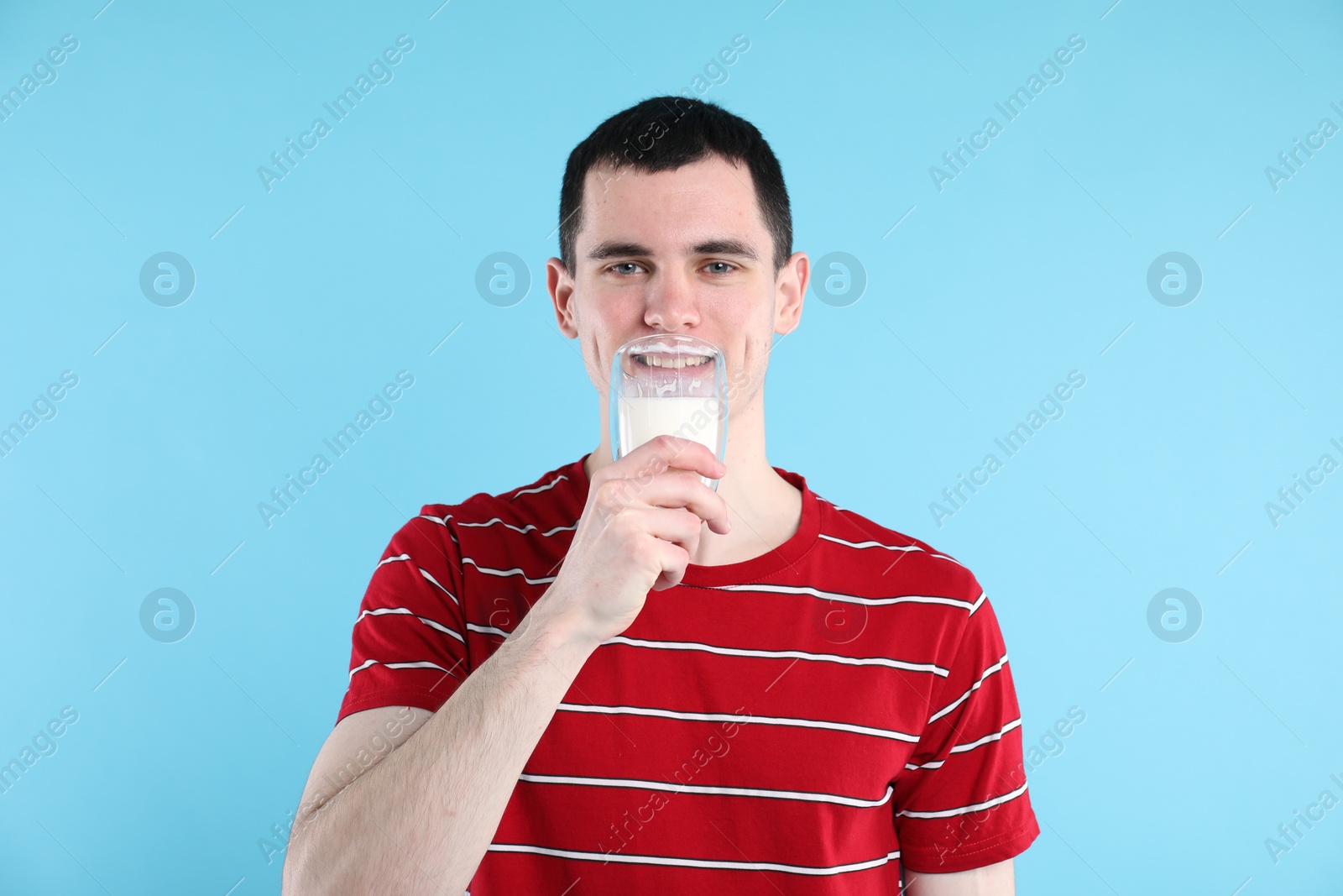 Photo of Milk mustache left after dairy product. Man drinking milk on light blue background