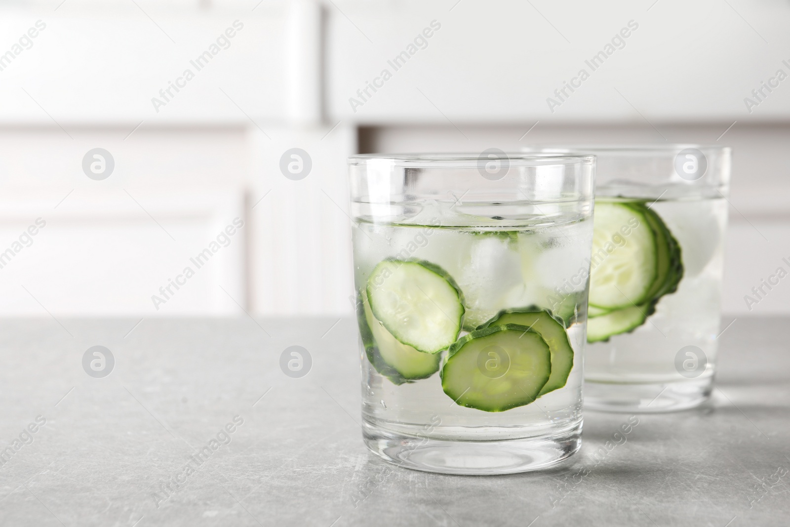 Photo of Glasses of fresh cucumber water on table. Space for text