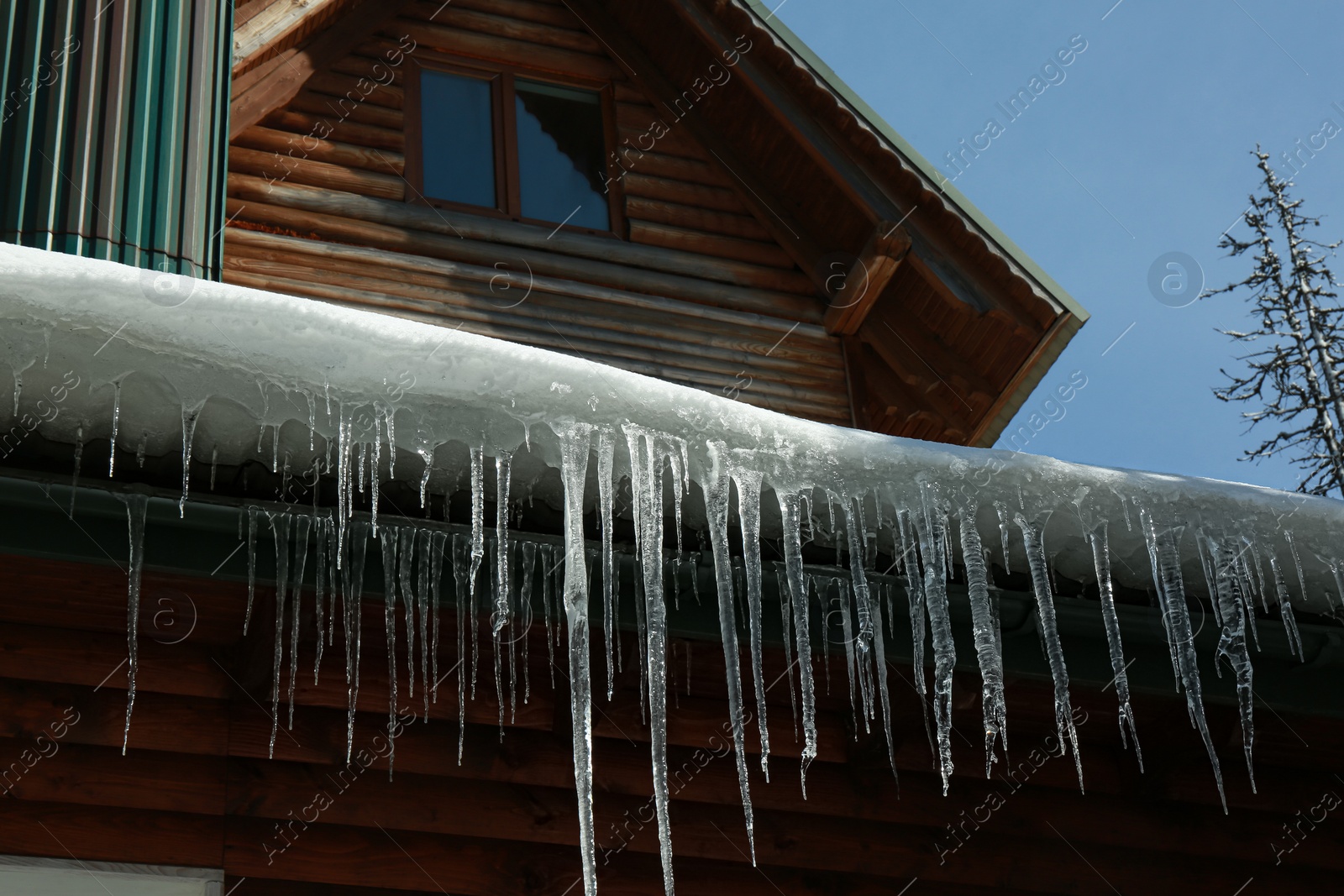 Photo of House with icicles on roof. Winter season