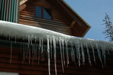 House with icicles on roof. Winter season