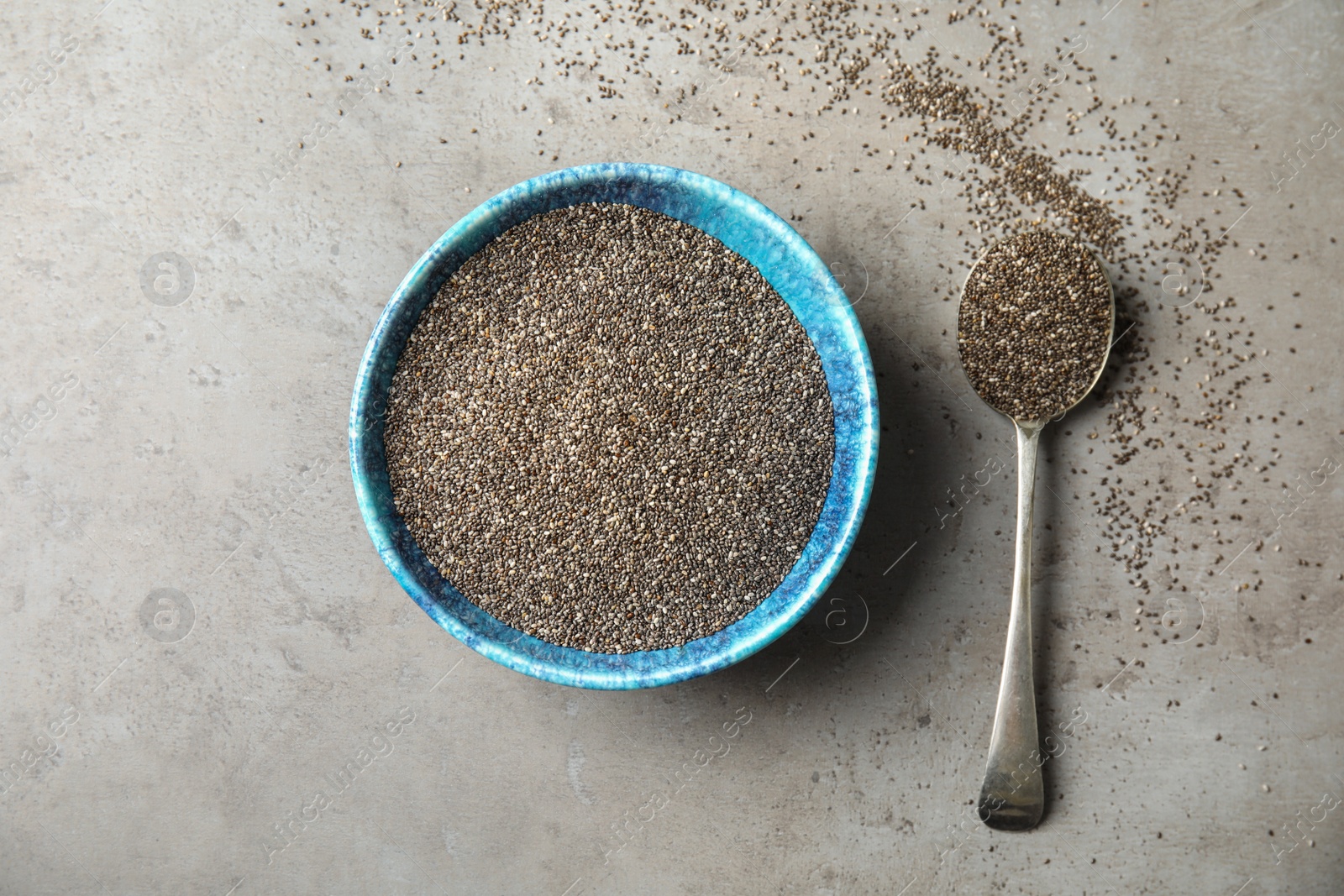 Photo of Bowl and spoon with chia seeds on grey background, flat lay