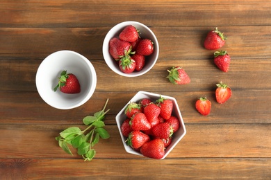 Flat lay composition with ripe red strawberries and mint on wooden background