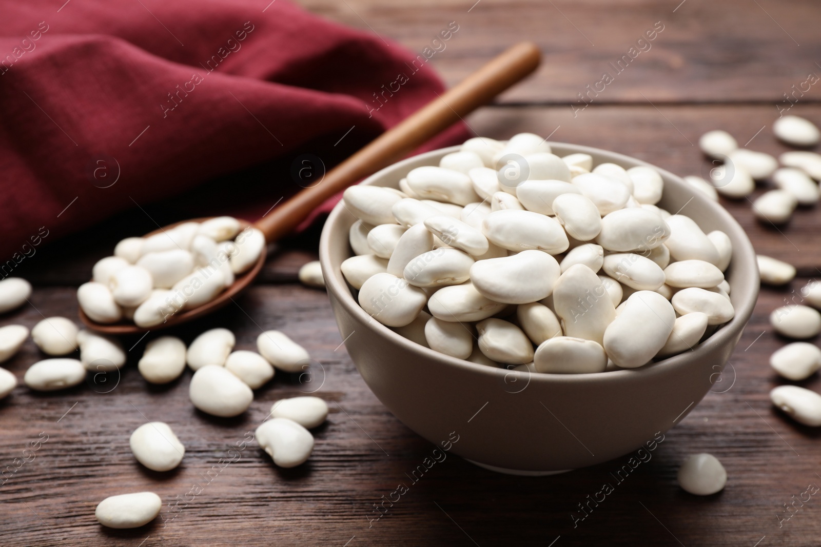 Photo of Raw white beans on wooden table, closeup