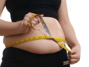 Woman measuring belly with tape on white background, closeup. Overweight problem