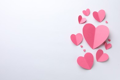 Pink paper hearts on white background, flat lay. Space for text