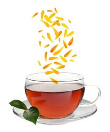 Image of Beautiful calendula petals falling into cup of freshly brewed tea on white background