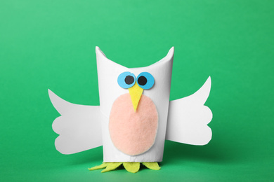 Photo of Toy owl made of toilet paper hub on green background