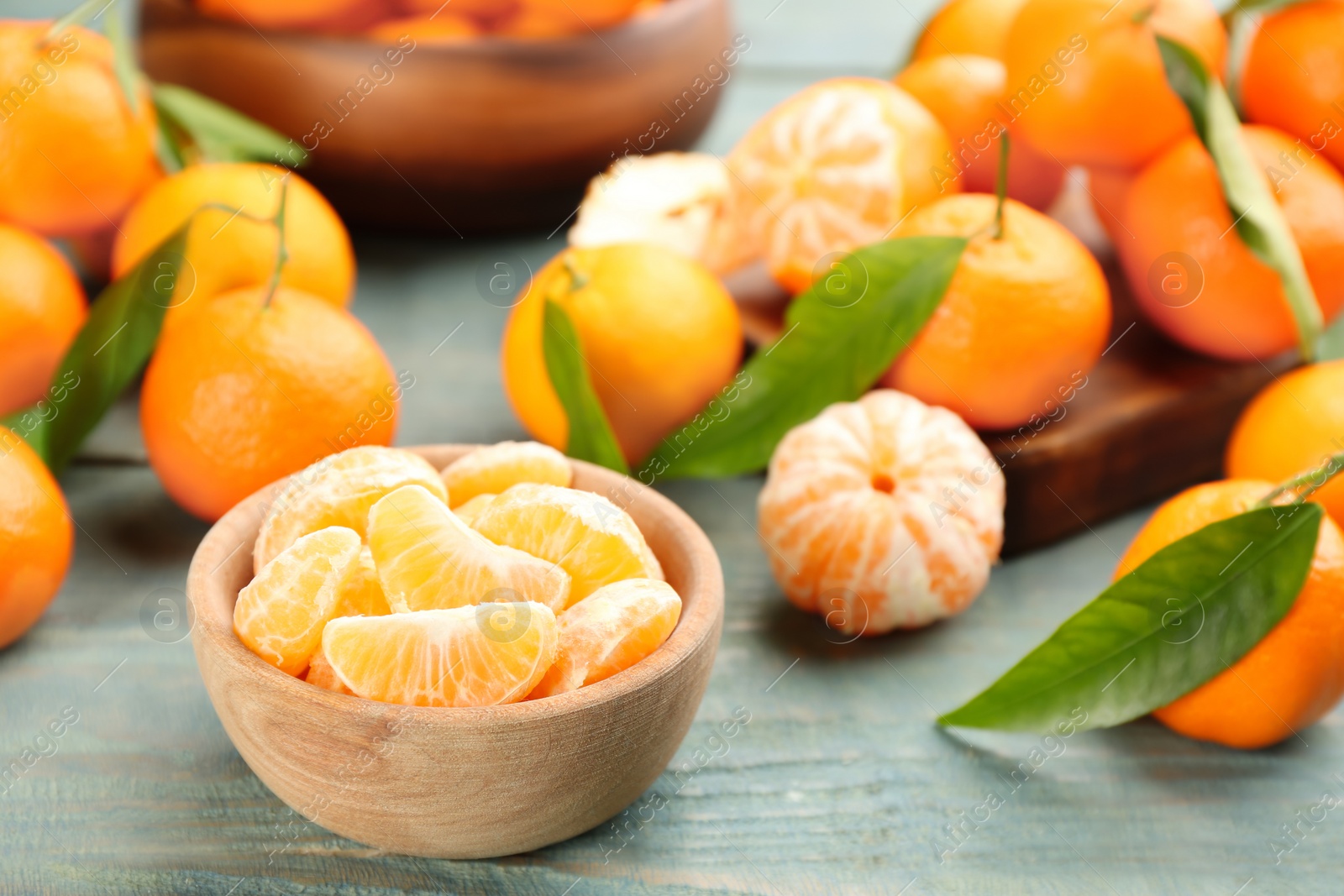 Photo of Fresh tangerine slices on blue wooden table