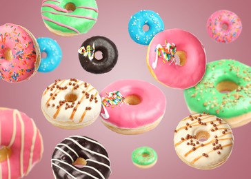 Image of Many sweet tasty donuts falling on pink background