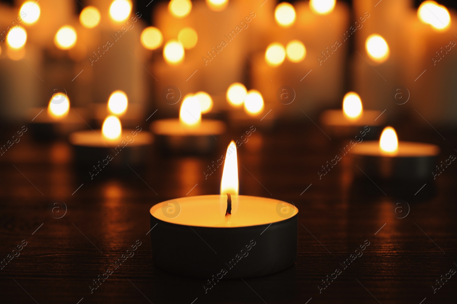 Photo of Burning candles on dark surface. Memory day