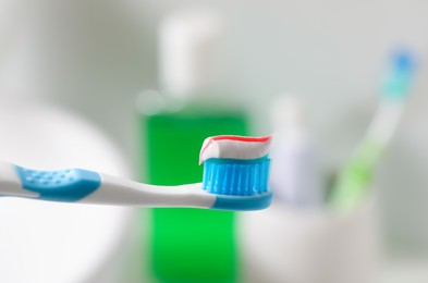 Photo of Toothbrush with paste against blurred background, closeup