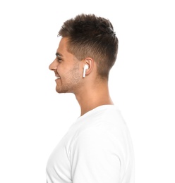 Happy young man listening to music through wireless earphones on white background