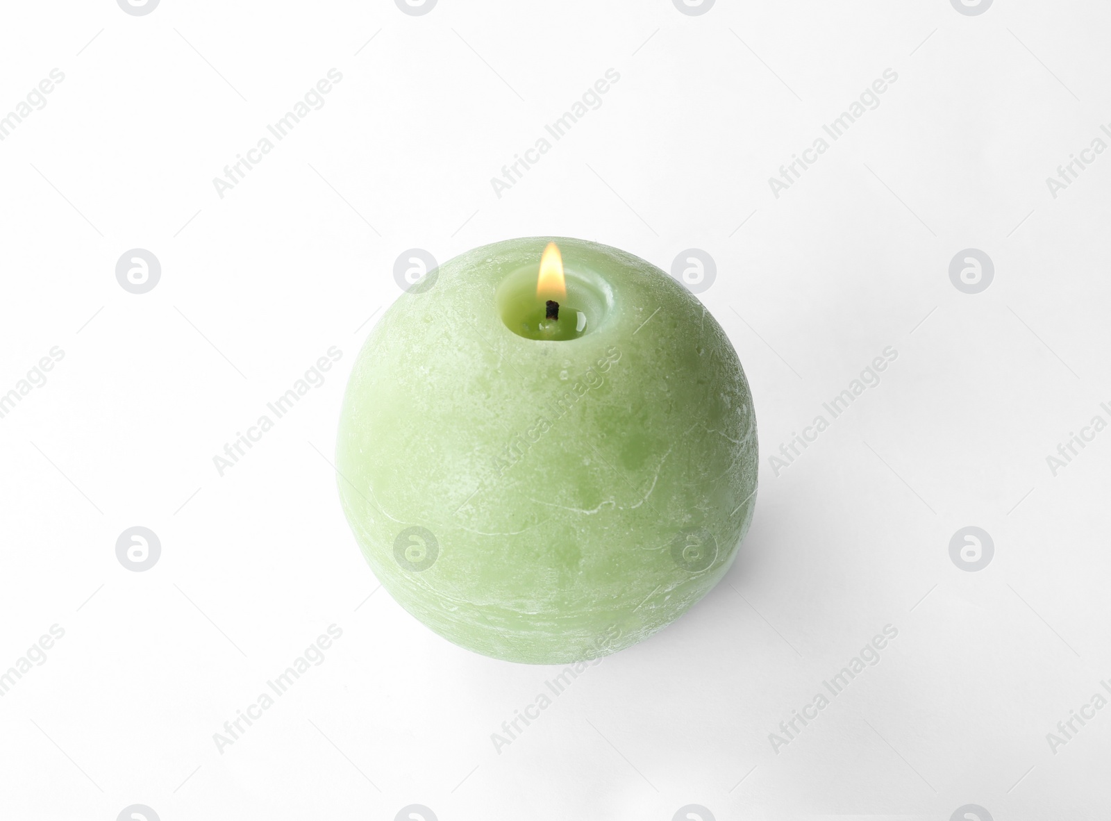 Photo of Small burning green candle isolated on white