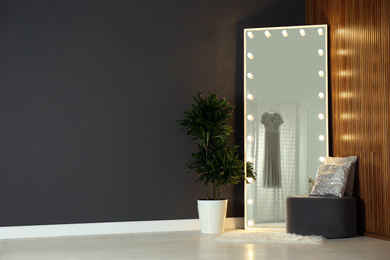 Photo of Modern mirror with lamps in room interior. Space for text