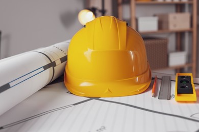 Photo of Construction drawings and different tools on table in office