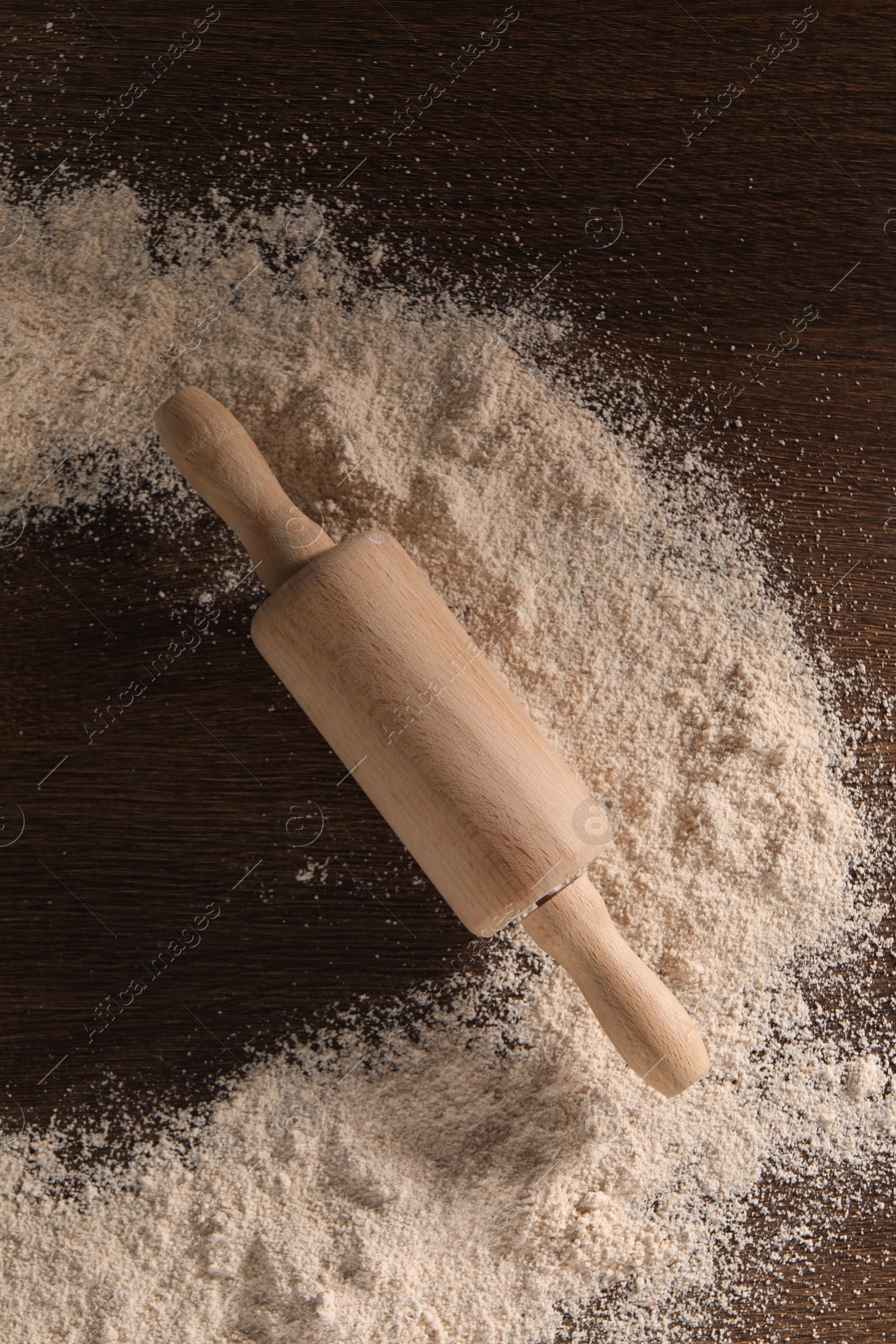 Photo of Frame of flour and rolling pin on wooden table, top view. Space for text