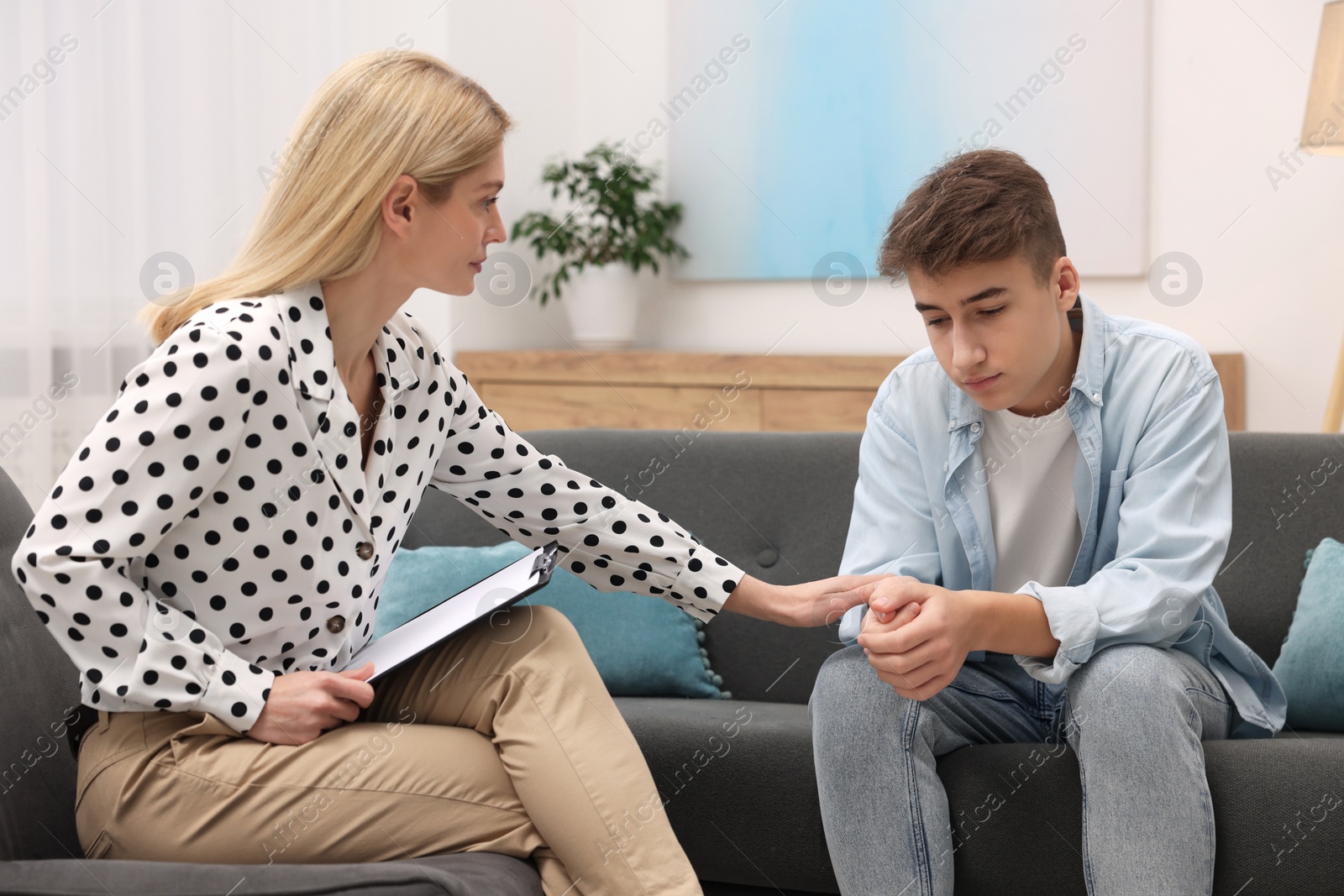 Photo of Psychologist working with teenage boy in office