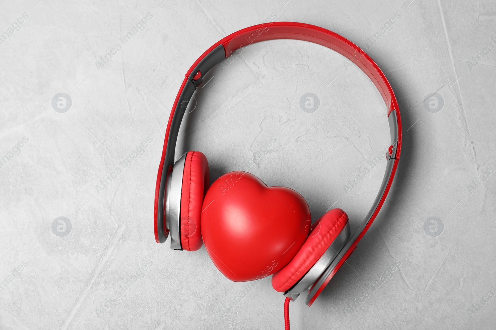 Photo of Headphones and heart on grey background, top view