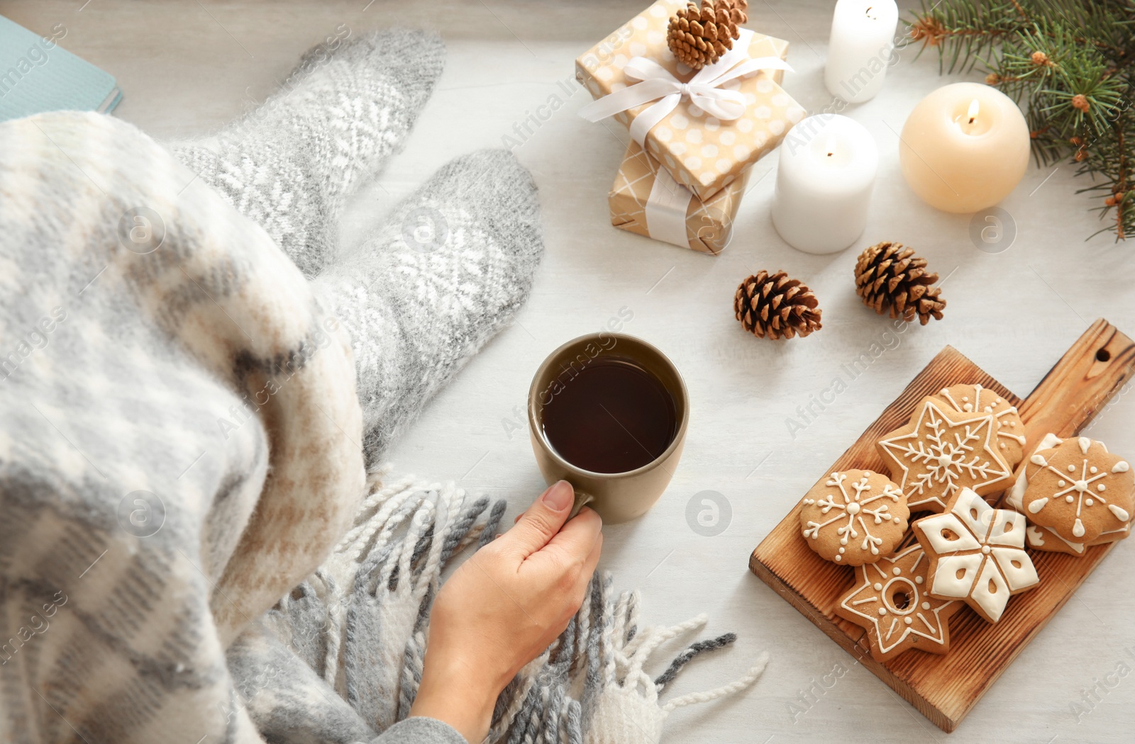 Photo of Woman relaxing with cup of hot winter drink at home, above view. Cozy season
