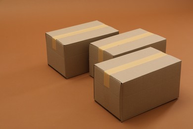 Photo of Group of closed cardboard boxes on brown background