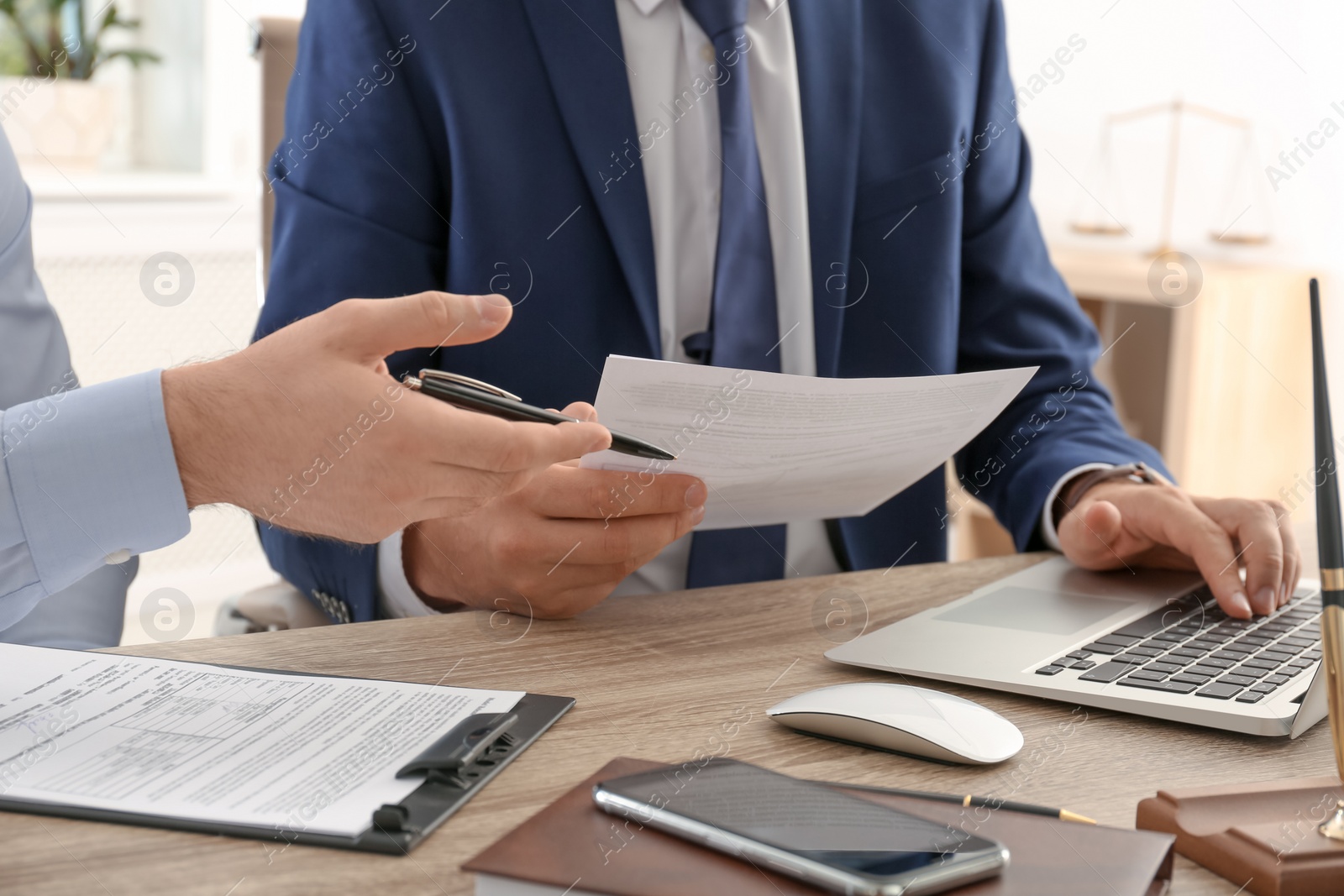 Photo of Lawyer working with client at table in office, focus on hands