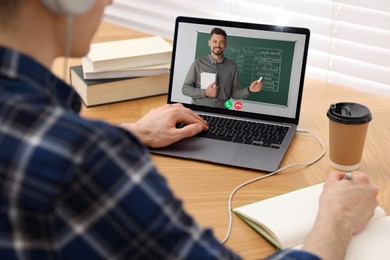 Image of E-learning. Young man having online lesson with teacher via laptop at home, closeup