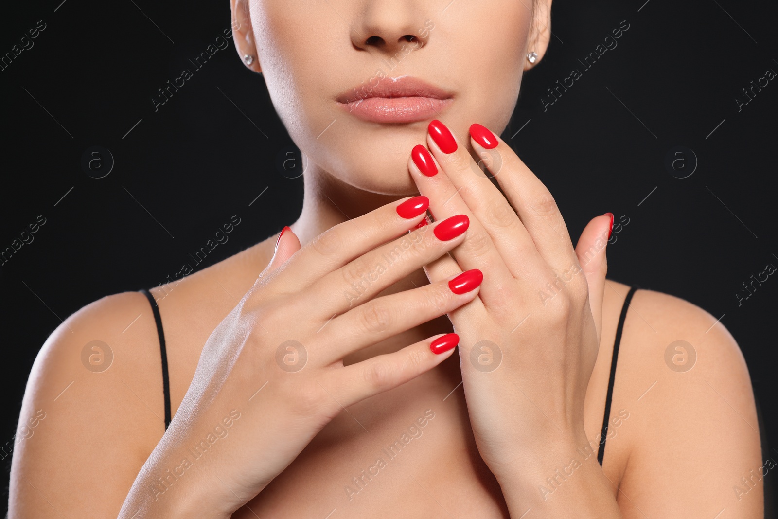 Photo of Beautiful young woman with bright manicure on black background, closeup. Nail polish trends