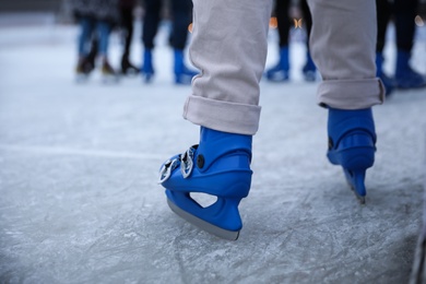 Person skating at outdoor ice rink, closeup