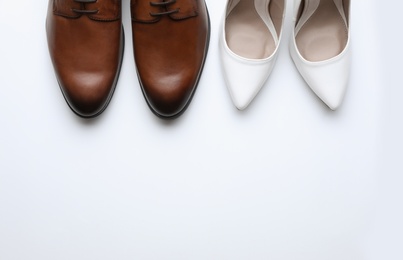 Photo of Wedding shoes for bride and groom on white background, top view