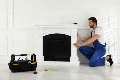 Professional technician installing electric fireplace in room