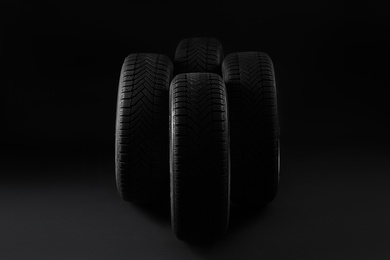 Set of new winter tires on black background