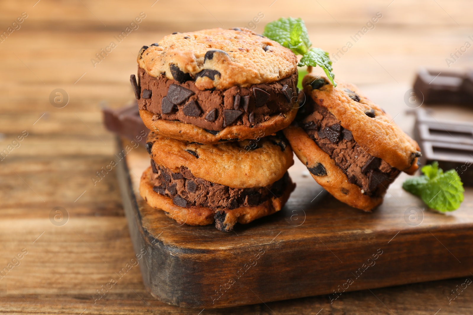 Photo of Sweet delicious ice cream cookie sandwiches on wooden table