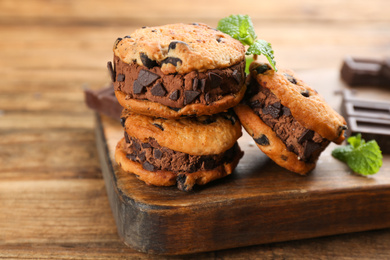 Photo of Sweet delicious ice cream cookie sandwiches on wooden table