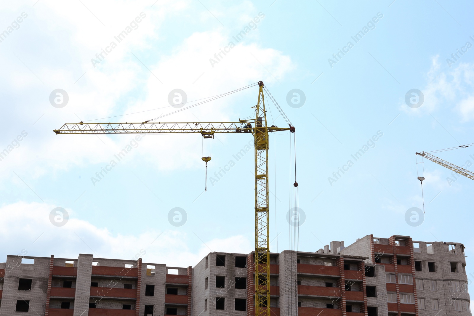 Photo of Construction site with tower crane near unfinished building