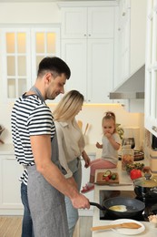 Photo of Happy lovely family cooking together in kitchen