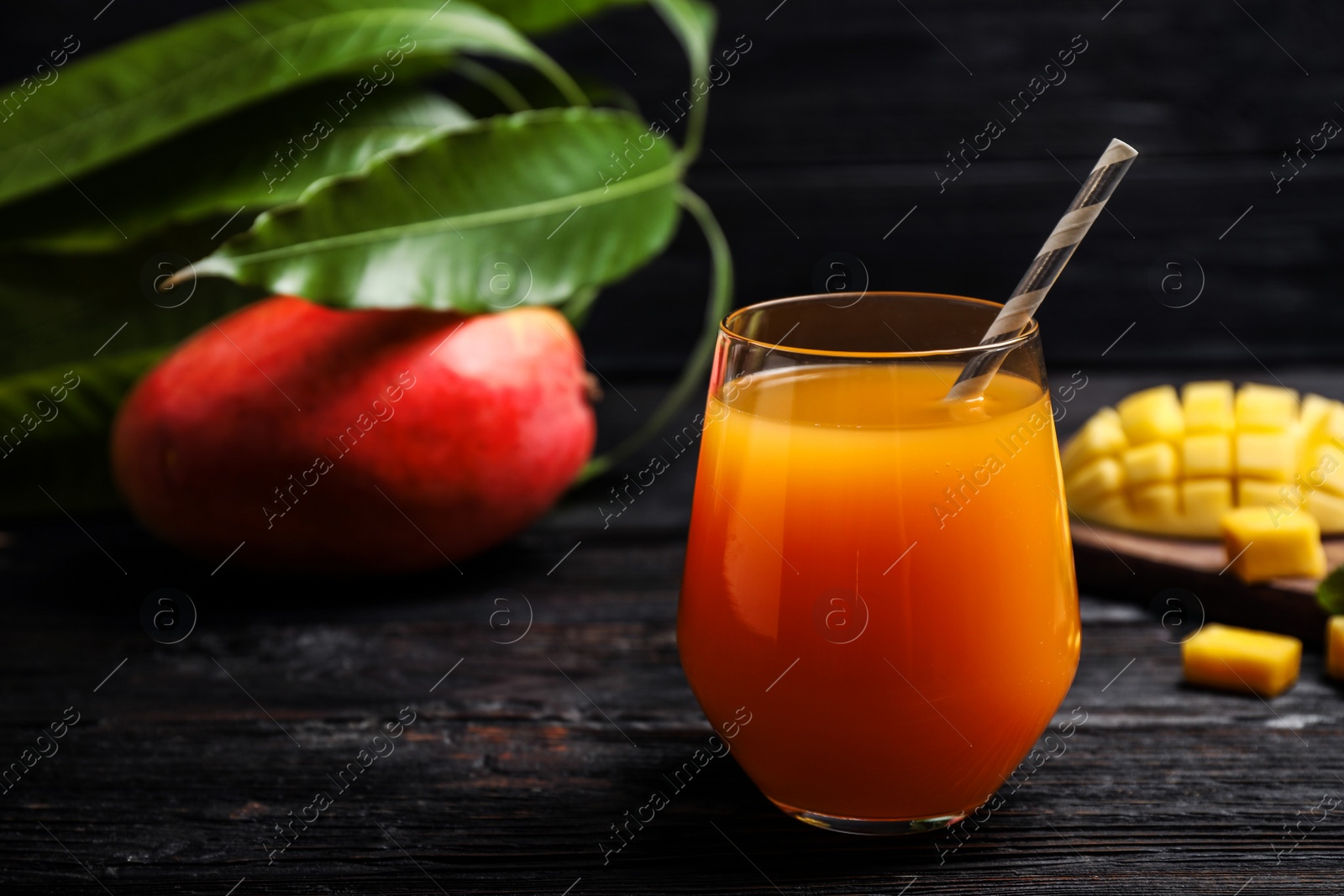 Photo of Fresh delicious mango drink on wooden table. Space for text