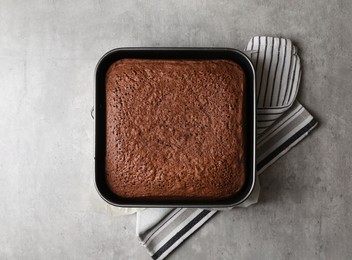 Homemade chocolate sponge cake on light grey table, top view