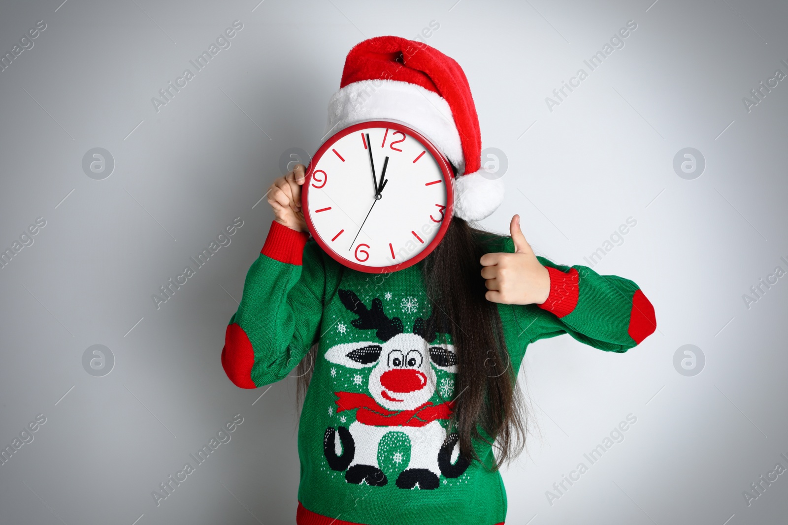 Photo of Girl in Santa hat with clock on white background. Christmas countdown