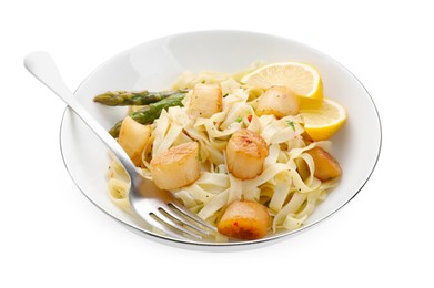 Photo of Delicious scallop pasta with asparagus, lemon and fork isolated on white