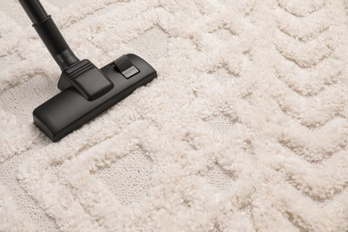 Photo of Hoovering carpet with modern vacuum cleaner. Space for text