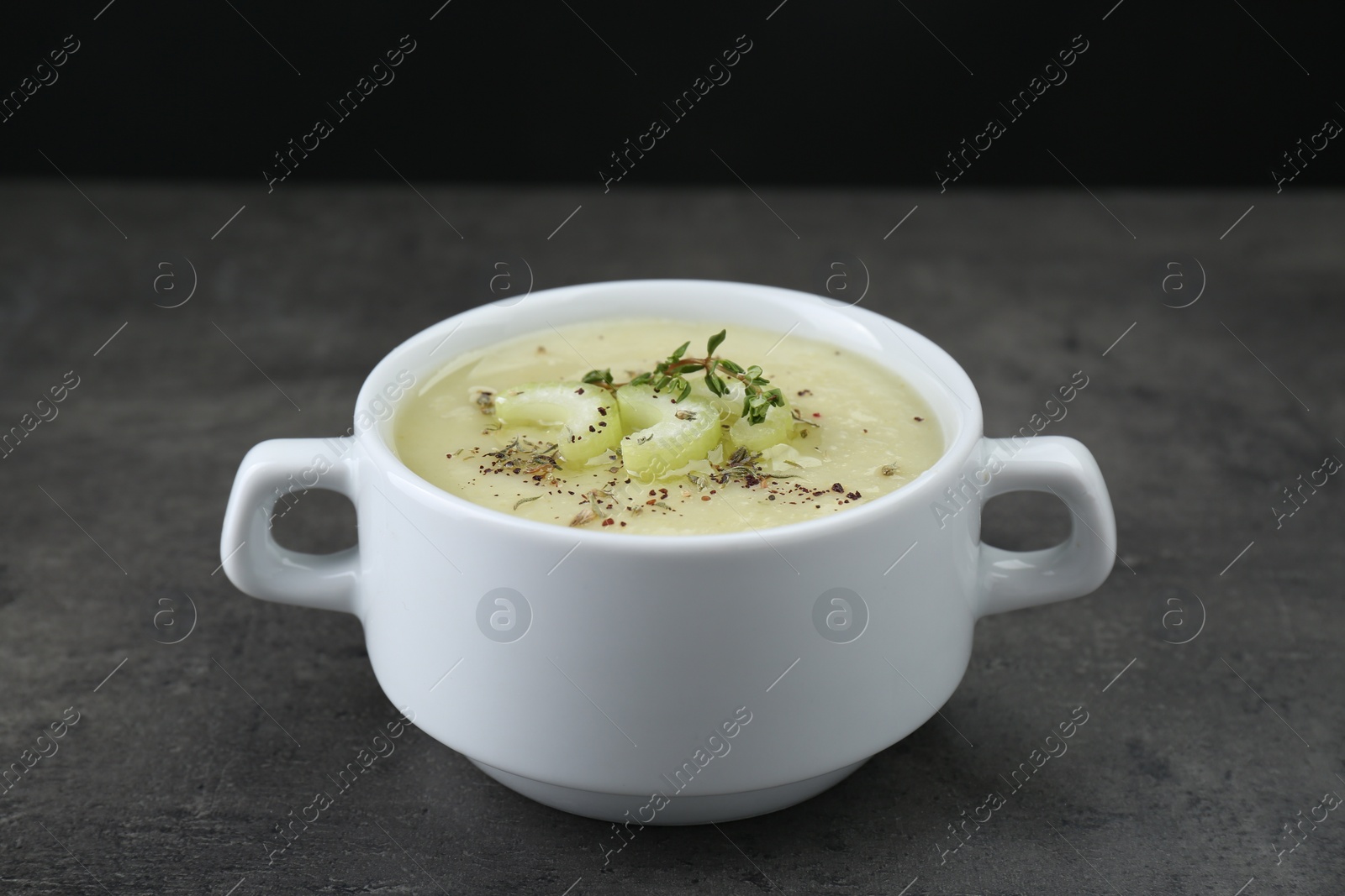 Photo of Bowl of delicious celery soup on gray table
