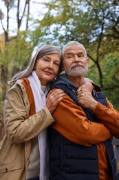 Photo of Portrait of affectionate senior couple in autumn park