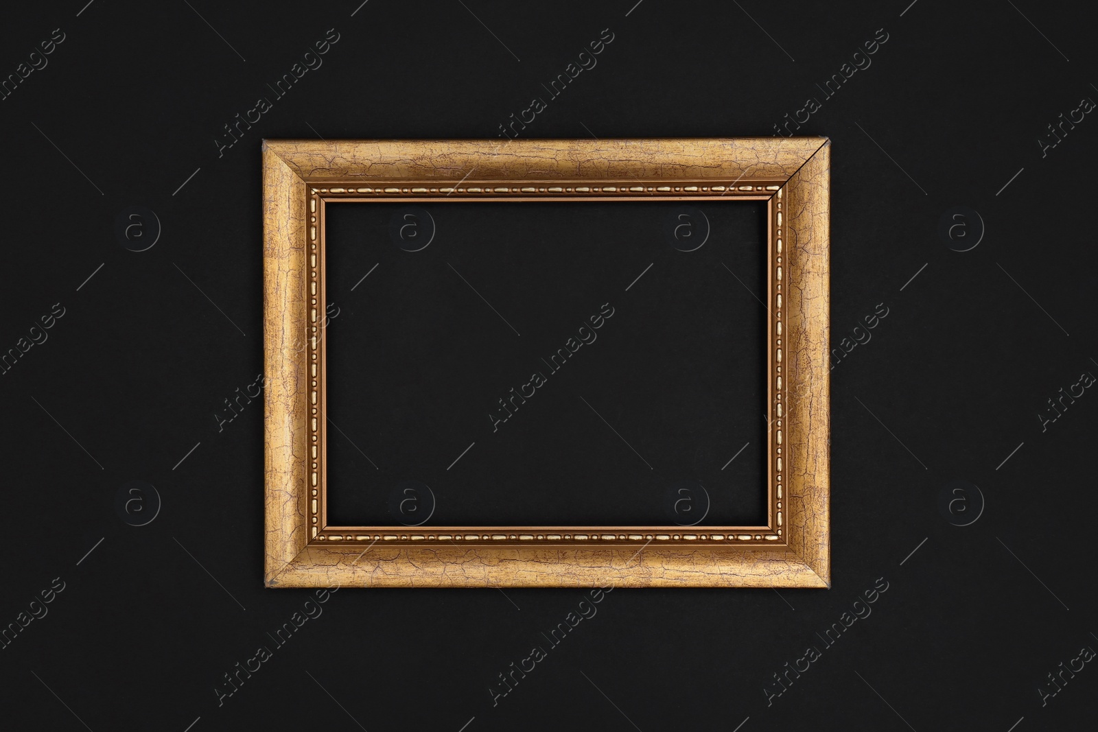 Photo of Gold painted frame on black background, top view with space for text