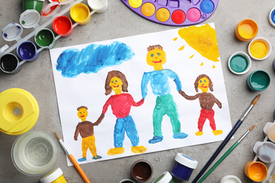 Flat lay composition with child's painting of family on grey table